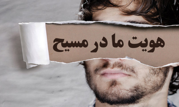 A man holds a torn paper with Persian text covering his eyes.