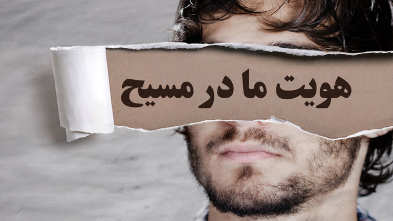 A man holds a torn paper with Persian text covering his eyes.