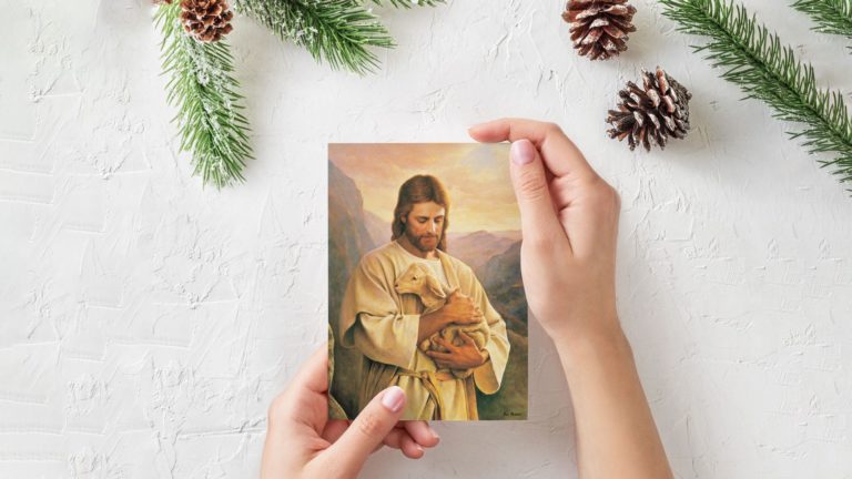 A person holding an image of Jesus carrying a lamb.