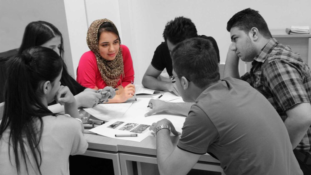 Group discussion with a woman leading the conversation.