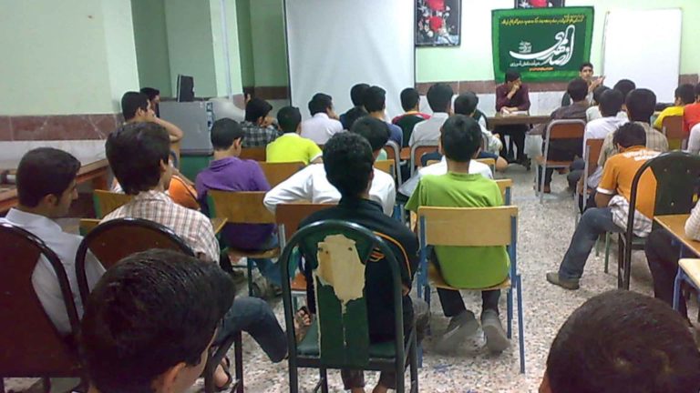 A group of men attending a presentation in a small room.