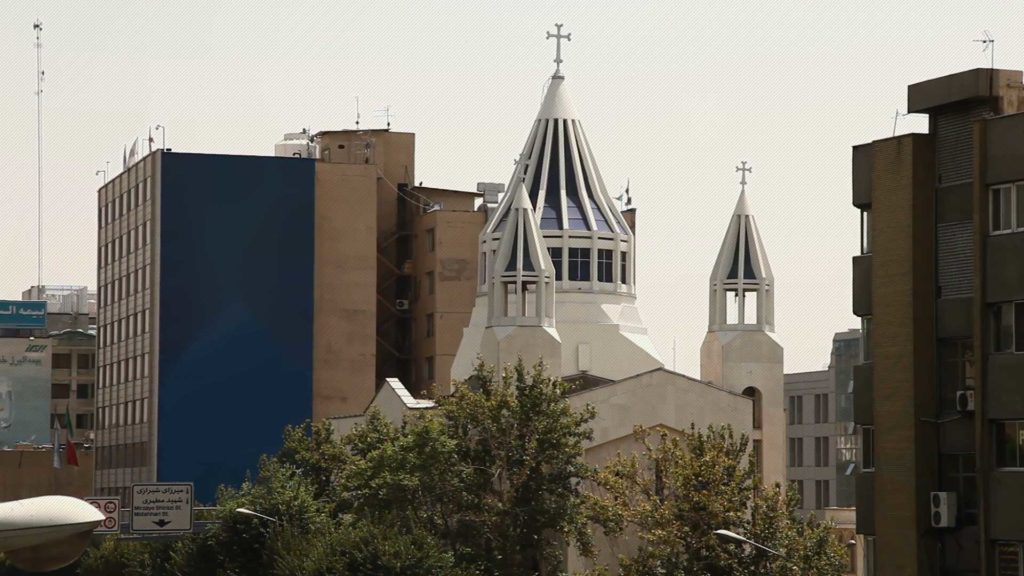 Urban view with church steeples and modern buildings in the background.