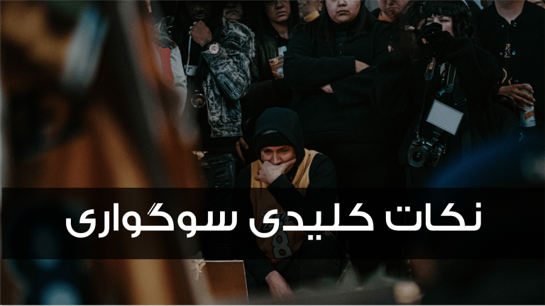A person wearing a mask and hat sits among a crowd, with Arabic text overlay.