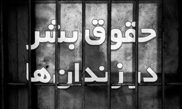 Graffiti in Persian script painted on a gridded window.